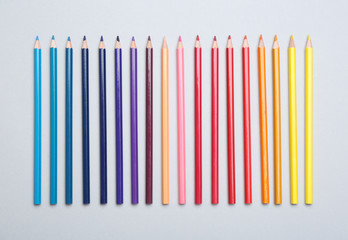 Colorful pencils on light background, flat lay