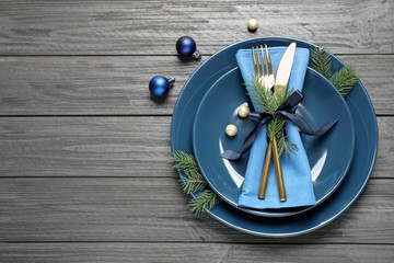 Christmas table setting on grey wooden background, flat lay. Space for text