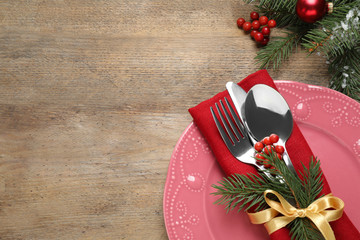 Christmas table setting on wooden background, flat lay. Space for text