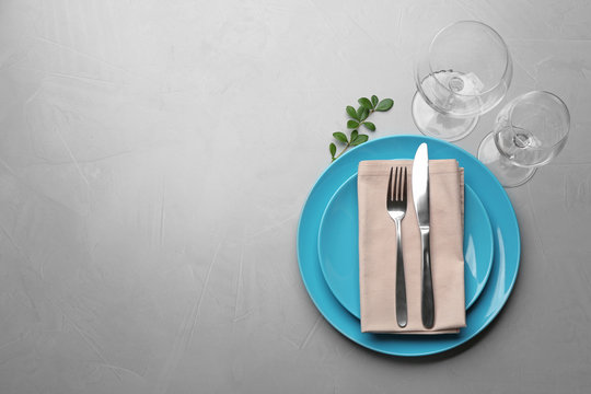 Elegant table setting on grey background, top view. Space for text