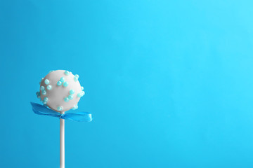 Tasty cake pop with bow on light blue background