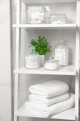 Cotton swabs and other hygiene products on shelving unit in bathroom