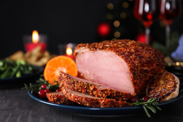 Plate with homemade Christmas ham on dark table, closeup