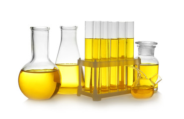 Laboratory glassware with yellow liquid on white background