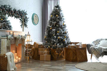 Stylish interior with decorated Christmas tree in living room