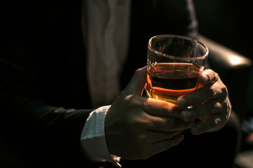 Closeup businessmen holding a glass of whiskey - Powered by Adobe