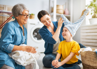 grandma, mom and child are doing laundry