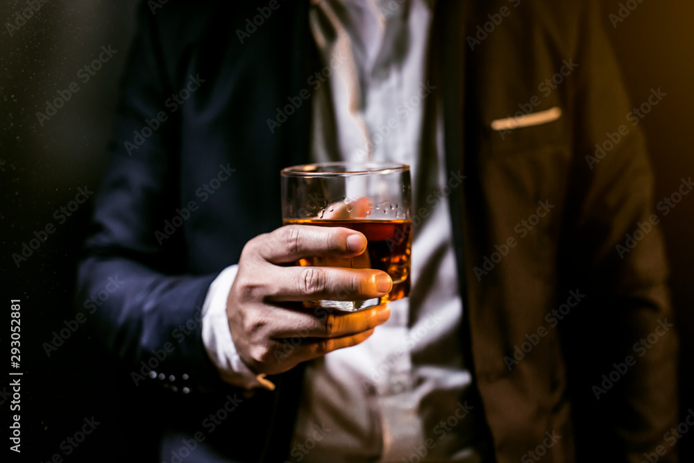 Wall mural Closeup businessmen holding a glass of whiskey