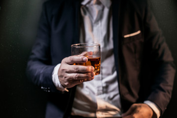 Closeup businessmen holding a glass of whiskey 