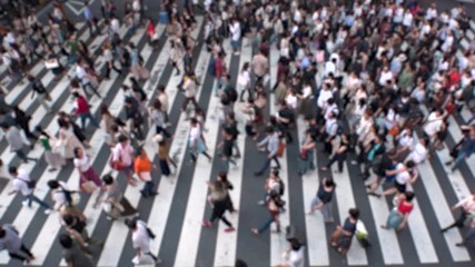 UMEDA, OSAKA, JAPAN - CIRCA SEPTEMBER 2019 : Aerial blurred view of zebra crossing near Osaka train station. Crowd of people at the street. Shot in busy rush hour. Slow motion.