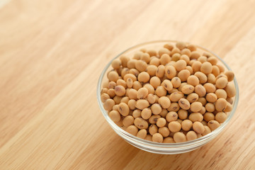 Soybeans are in a cup, placed on a wooden table with copy space,Dry bean yellow  color