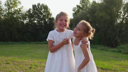 Authentic shot of two cute happy little carefree girls sisters are having fun and enjoying their time together in a nature on a sunny day.