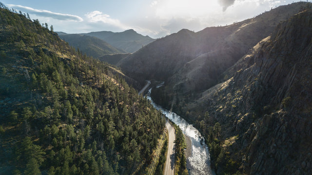 High perspective view looking through a winding river canyon on a warm sunny afternoon © Matt Kilroy