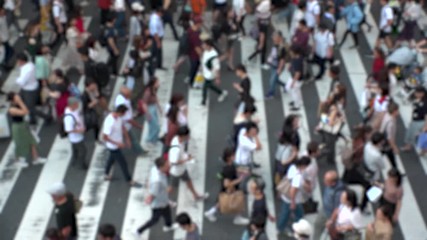 UMEDA, OSAKA, JAPAN - CIRCA SEPTEMBER 2019 : Aerial blurred view of zebra crossing near Osaka train station. Crowd of people at the street. Shot in busy rush hour. Slow motion.