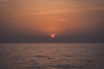 Dramatic sunset over the ocean , Golden sunrise sunset over the sea ocean waves, Magnificent View Bright Horizon, uae beach , variety of colors and hues of the rising sun