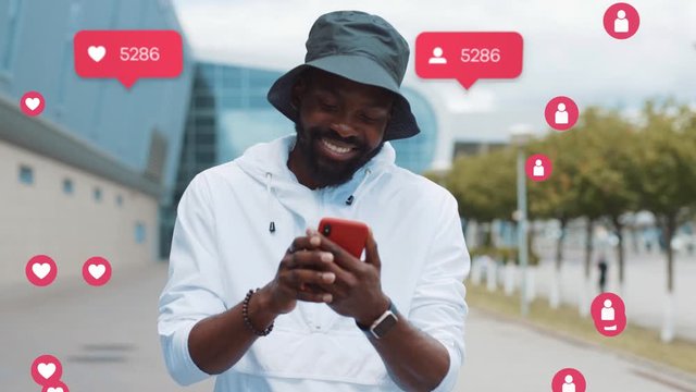 Stylish African American Man Uses Phone Smiles City. Vlogger Influencer. Animation with User Interface - Likes, Followers, Comments for Social Media from Smartphone. Response. Successful Emotion. Live
