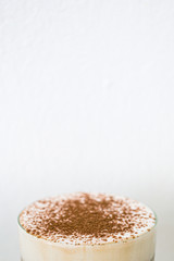 Cocoa powder in a glass on white background
