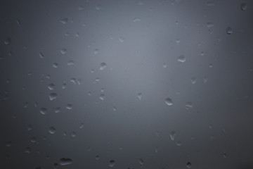 Raindrops on window with grey background