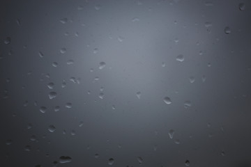 Raindrops on window with grey background