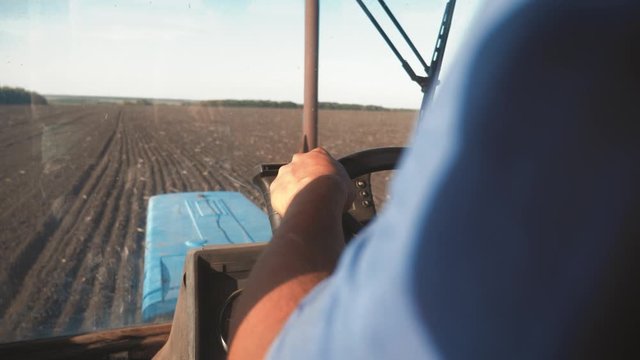 Farmer driving tractor in cultivating field. Agricultural works at tractor.