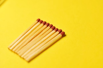 Symbol of danger with matches on yellow  background top view , pile of match arrange in a row , unlit matches 