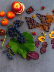 anticancer food, good for cardiovasculas system, fresh ripe grape, dark chocolate, raspberries, tomatoes, apple, beet on concrete background. Food rich in resveratrol, antioxidants