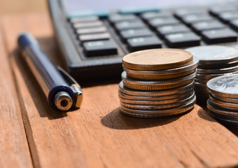 Coins and pens on calculators for calculating business concepts..
