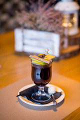 Hot red mulled wine for winter and Christmas with orange slice, anise and cinnamon sticks isolated on wooden background, closeup. Hot drinks