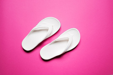 Flip flops on a pink isolated background. White female flip flops.