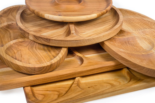 Stack of different wooden compartment dishes and serving boards closeup