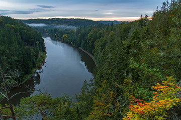 Vltava river from vantage point with autumn foliage at sunrise