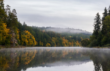 Fototapeta premium Amazing misty fog on Vltava river with autumn foliage
