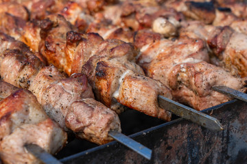 Grilled kebab cooking on metal skewer closeup. Roasted meat cooked at barbecue. BBQ fresh beef meat chop slices. Traditional eastern dish, shish kebab