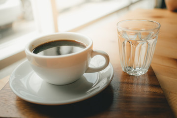 Hot cup of Americano coffee on wooden desk.