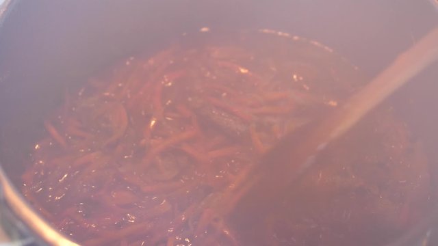 Boiling meat crots with carrots when cooking Plov traditional dish from Uzbekistan