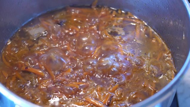 Boiling meat crots with carrots when cooking Plov traditional dish from Uzbekistan