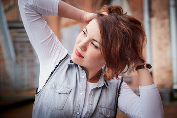 Naklejka premium Brunette funny pretty girl on roof in Central part of old city. Walk in downtown. Portrait of a girl on the street