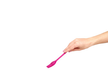 Hand with pink culinary brush, kitchen utensil.