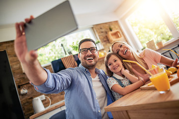 Happy family makes orange juice for breakfast