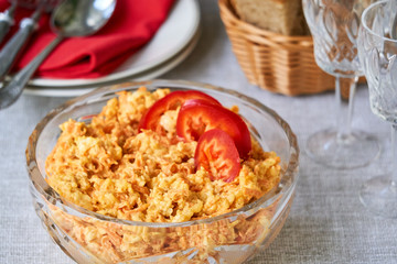 Rice salad with carrots and cheese in a glass bowl