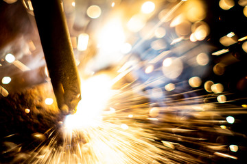 abstract close-up image of blurred sparks and smoke from arc welding with bokeh effect