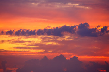 Hermoso cielo con nubes al amanecer con colores vivos, rojos y anaranjados.