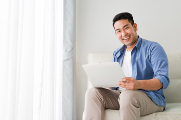 Asian handsome man working with laptop computer   in living room happy and smile face - 293067018