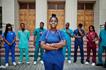 Group of african medical students posed outdoor against university door.