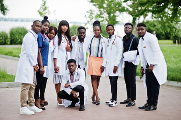 Group of african medical students posed outdoor in white lab coats.