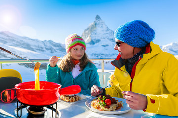 Fondue cheese, swiss winter ski holidays break for lunch, mountain view Matterhorn in Zermatt, Switzerland.