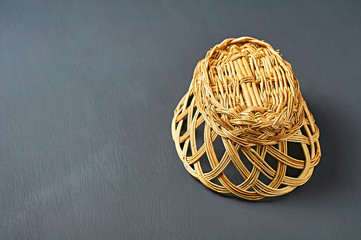 One inverted empty oval wooden wicker basket for bread, fruits or others food products lies on dark...