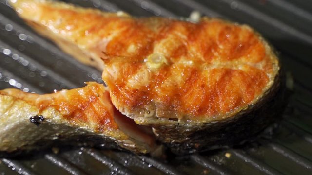 frying salmon in black pan
