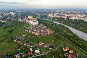 Aerial view of Ivano-Frankivsk city with residential area and suburb houses with a river in middle.
