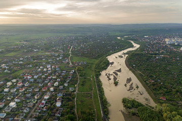 Aerial view of Ivano-Frankivsk city with residential area and suburb houses with a river in middle.